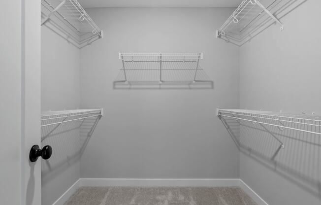 the spacious walk-in closet in the master bedroom of a manufactured home with two hanging closets