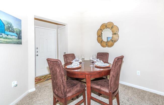 Apartment dining area with four wine glasses and place settingsÂ 