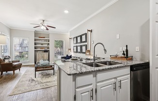 A kitchen with a marble countertop and a ceiling fan.
