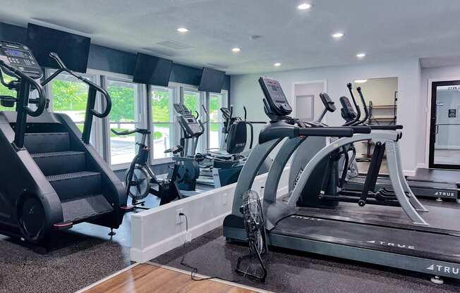 A gym with treadmills, elliptical machines, and a stair climber.
