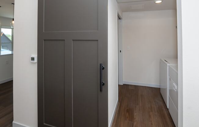 a bedroom with a door and a hallway with a laundry room at The Crossings at Windsong, Prescott Valley, AZ