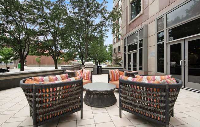 a patio with chairs and a table in front of a building