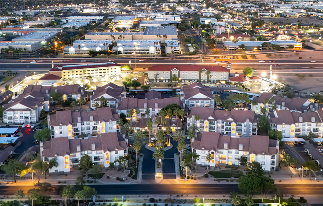 A large complex of houses with a glowing street in front.