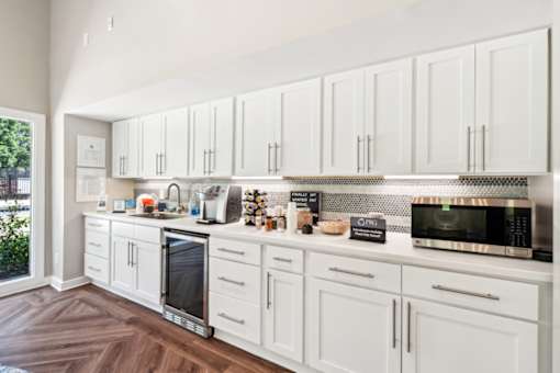 A kitchen with white cabinets and a wood floor.