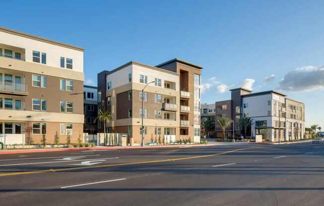 A row of modern apartment buildings line a street.