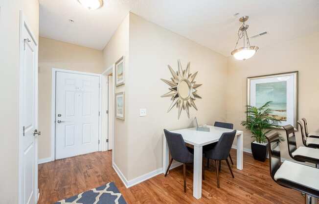 a dining room with a table and chairs and a mirror