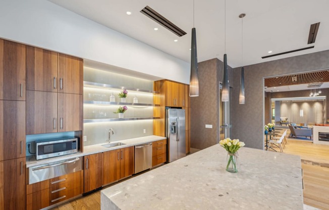 a large kitchen with wooden cabinets and a marble counter top at The Merc, Waltham