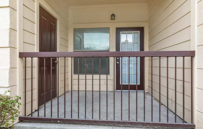 a balcony with a fence in front of a house