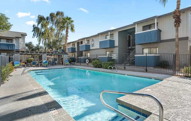 A swimming pool surrounded by a fence and palm trees.