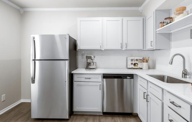 a kitchen with white cabinets and stainless steel appliances  at Sunset Heights, Texas