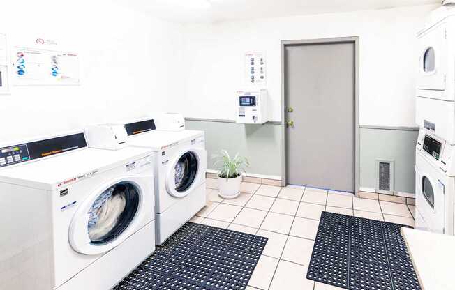 A laundry room with washing machines and a door.