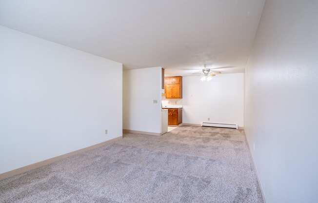 A room with a carpeted floor and a small wooden cabinet. Fargo, ND Islander Apartments