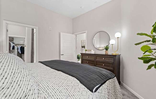 A bedroom with a large bed and a mirror on the wall.