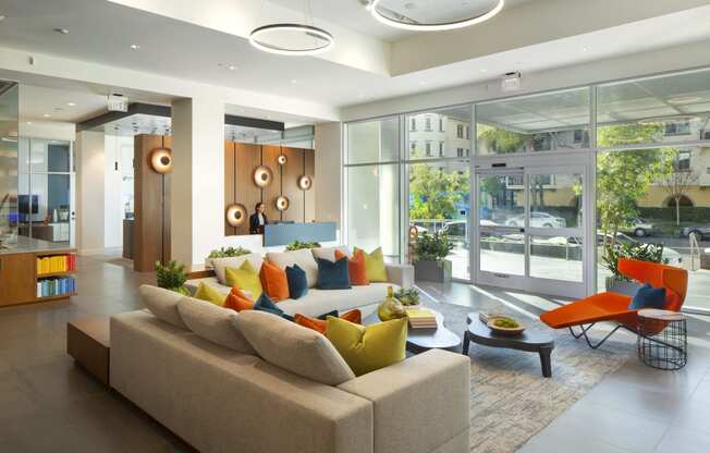 Apartments in Woodland Hills, CA - The Q Variel - Main Lobby With 24-Hour Concierge, Comfortable Seating, Modern Designs, and Secured Fob Access Sliding Doors