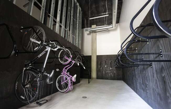 a row of bikes hanging on a wall next to a staircase at Analog PDX Apartments, Portland, OR