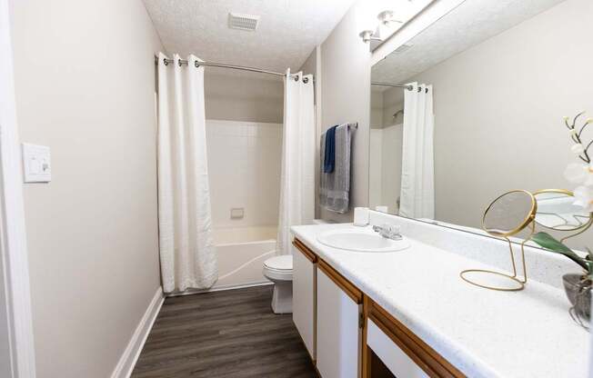 A bathroom with a white sink and a white toilet.