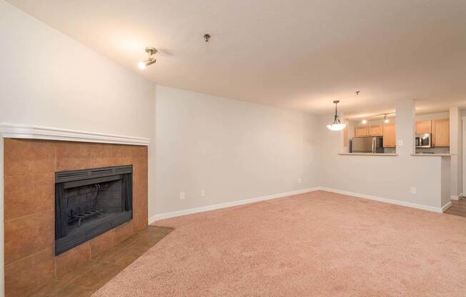 A living room with a fireplace and carpeted floor.