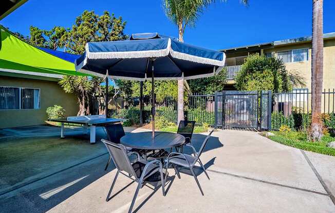 A patio with a table and chairs under a canopy.
