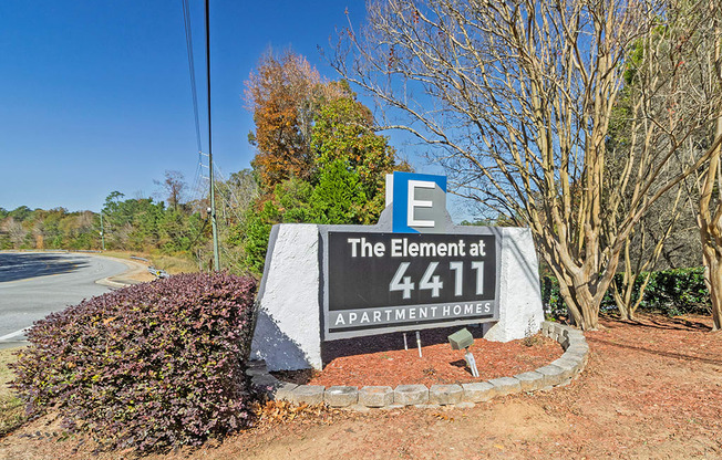 Element at 4411 Macon Apartments A sign for The Element at 4411 APARTMENT HOMES is in front of a road.