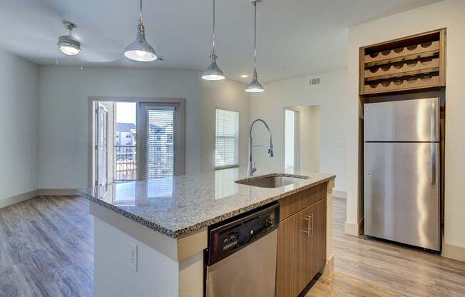 A kitchen with a granite countertop and stainless steel appliances.