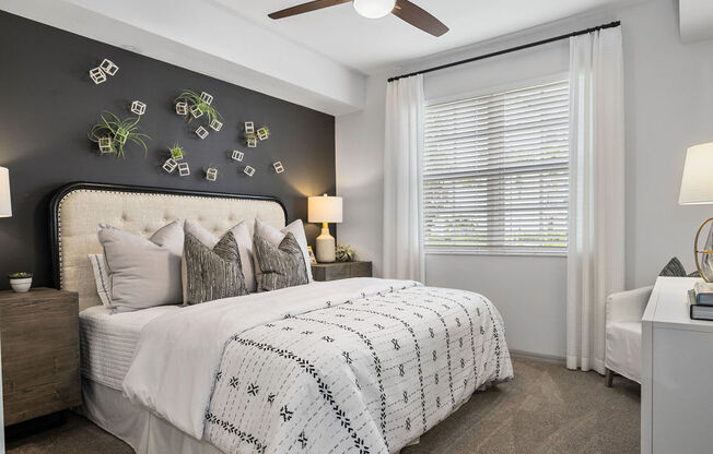 a bedroom with a bed and a ceiling fan