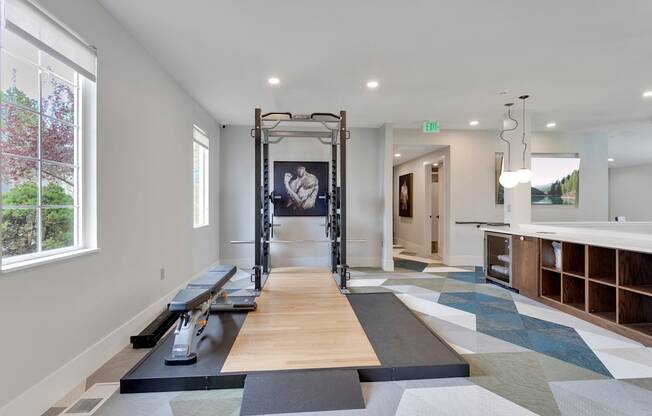 A gym with a row of treadmills and a pull up bar.