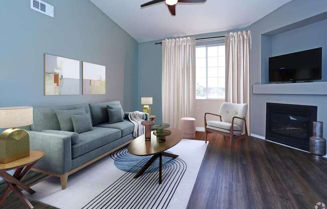 A living room with a grey couch, a fireplace, and a ceiling fan.