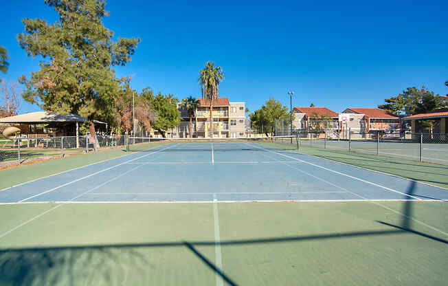 A tennis court with a blue sky in the background.