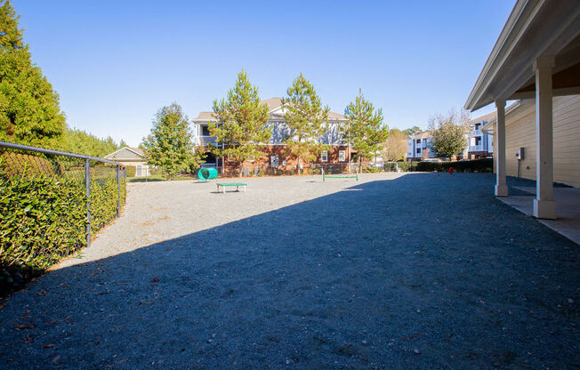 a large yard with a playground and houses in the background