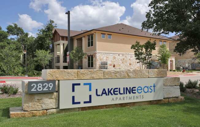a view of the lakeline east apartments sign with a house in the background