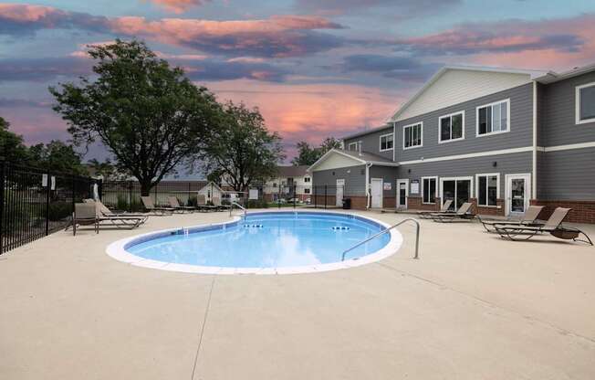A swimming pool in a backyard with a house in the background.