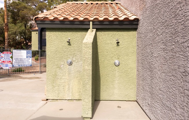 a small yellow building with a tiled roof and two doors