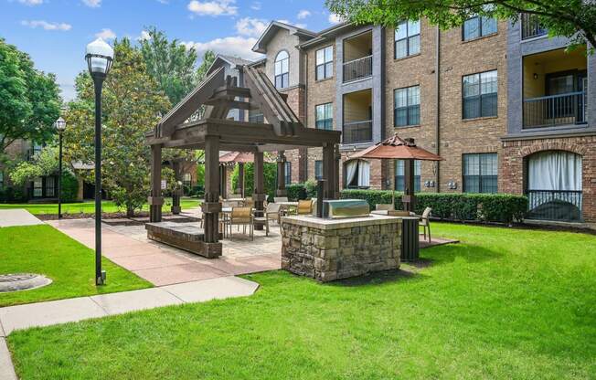 a patio with a gazebo in front of an apartment building