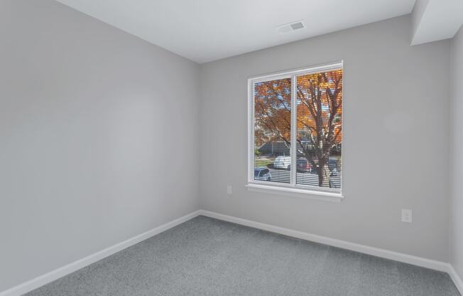 an empty room with a large window in the center of it