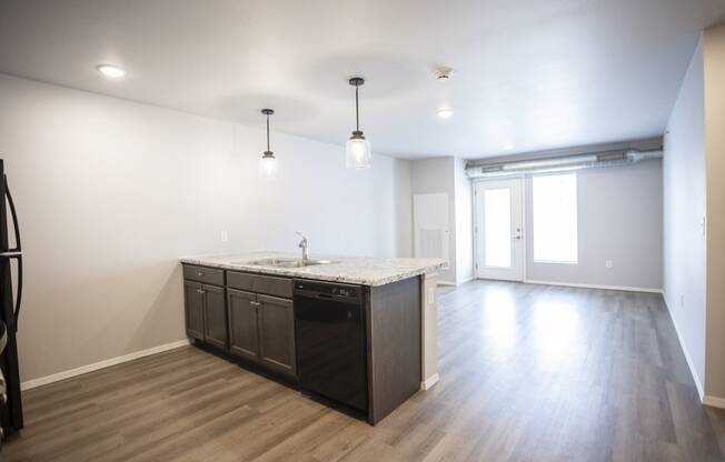 Spacious, combined kitchen and living room with breakfast bar seating.