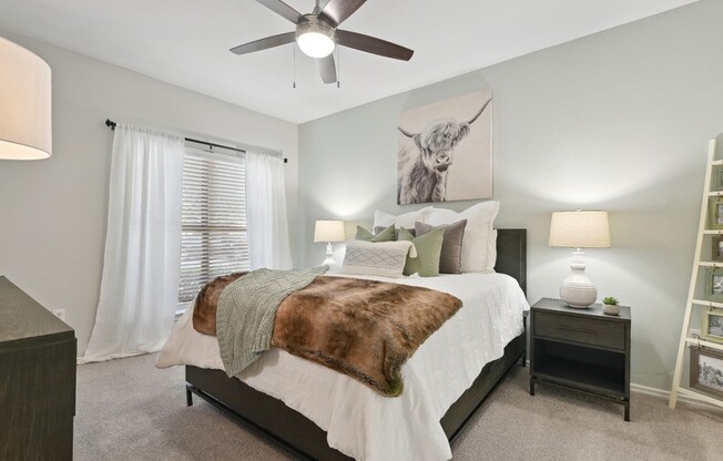 A bedroom with a large bed and a ceiling fan.
