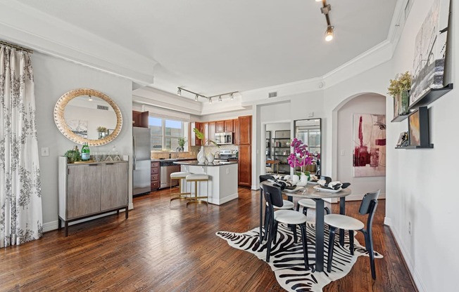 Model apartment dining room with a zebra print rug and a round mirror on the wall at Dominion Post Oak apartments in Houston, TX