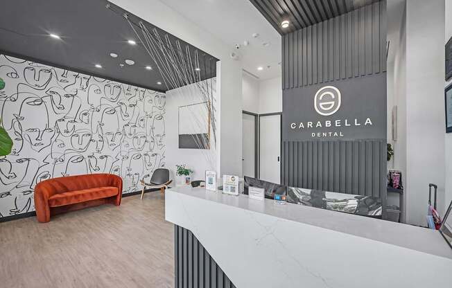 A dental office with a white reception desk and a red couch.