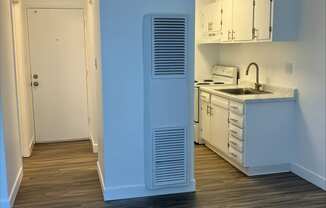 an empty kitchen with white cabinets and a white refrigerator