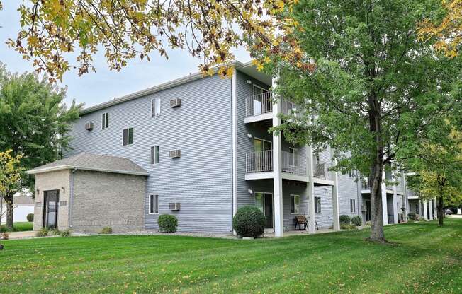 An exterior of a three level apartment with a large grass area out front. Fargo, ND Flagstone Apartments.