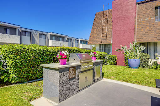 A small stone memorial with a plaque and flowers sits in front of a building.