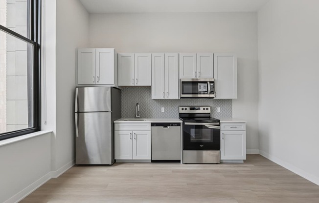A kitchen with white cabinets and stainless steel appliances.