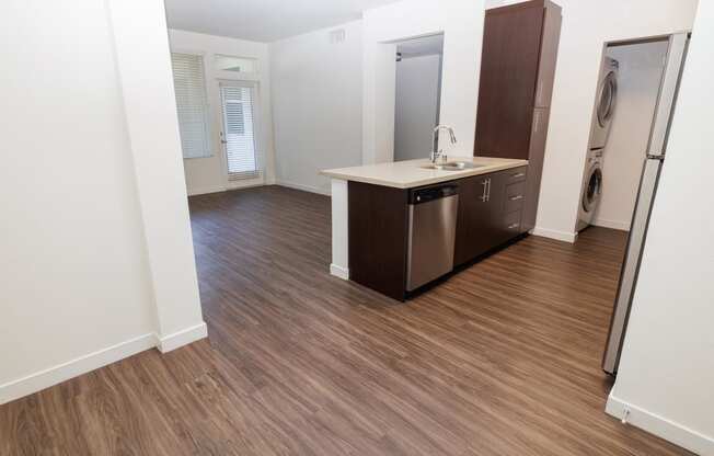 an empty bathroom with a washer and dryer in a room with wood floors