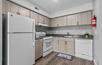 A kitchen with white appliances and wooden cabinets.