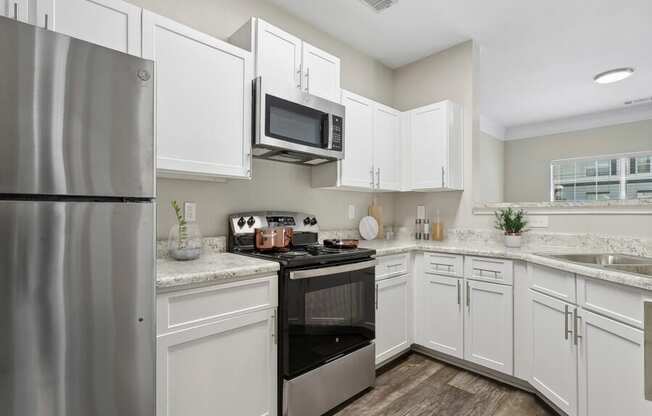 Model apartment kitchen with stainless steel appliances and white cabinets