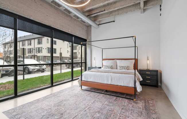 a bedroom with a bed and a large window