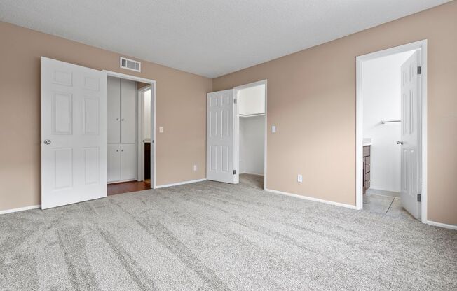 a bedroom with two doors and a carpeted floor