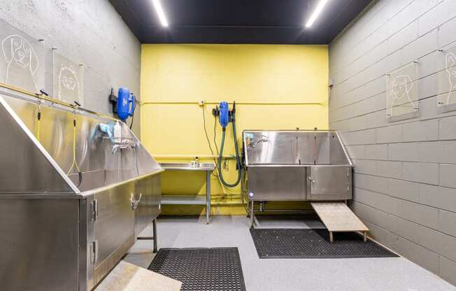 the utility room has two stainless steel sinks and two urinals