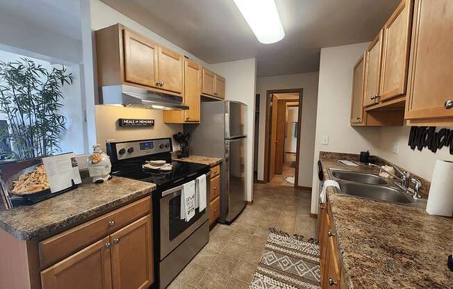 A kitchen with brown cabinets and a granite counter top.