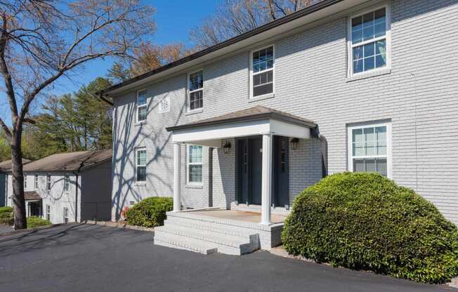 a white house with a front porch and a driveway